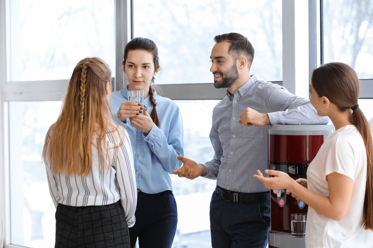 People smiling together after drinking water from a bottled water cooler