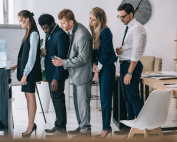 People lining up at a bottled water cooler in a London office