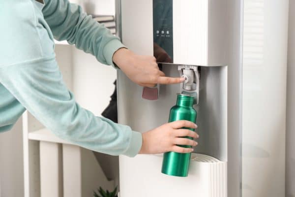 Woman refills her water bottle at a water cooler