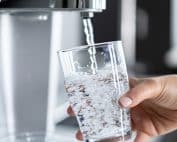 Crystal-clear drinking water in a glass from a modern filtered water dispenser