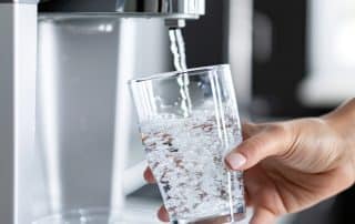 Crystal-clear drinking water in a glass from a modern filtered water dispenser